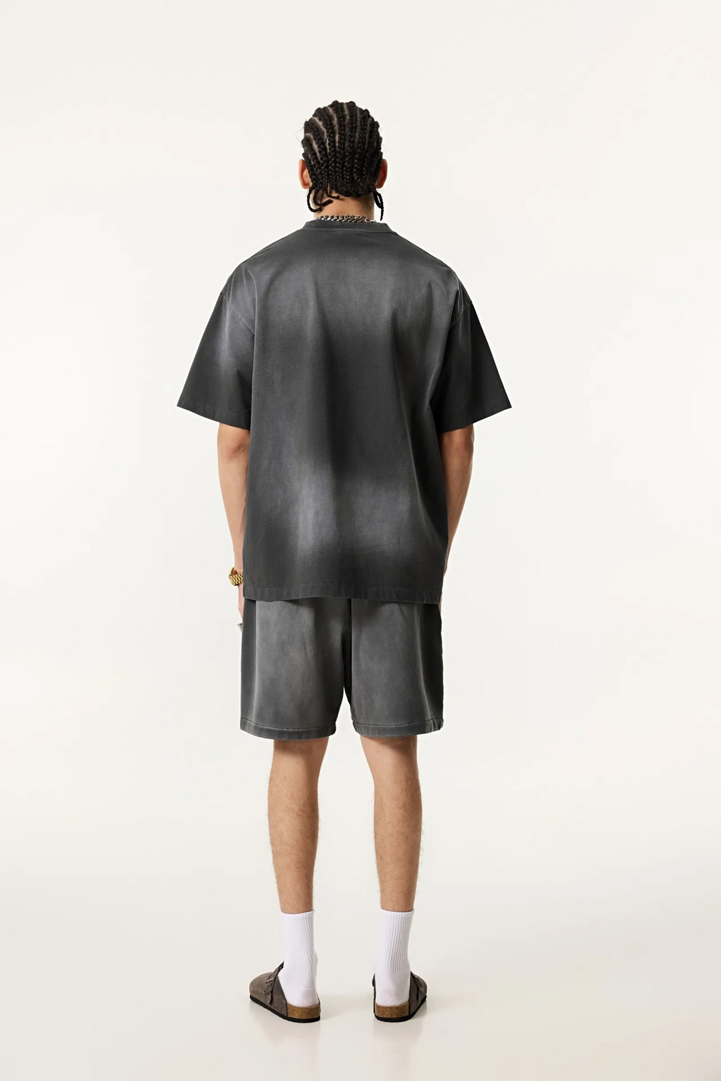 Person wearing a black leather outfit on a white background