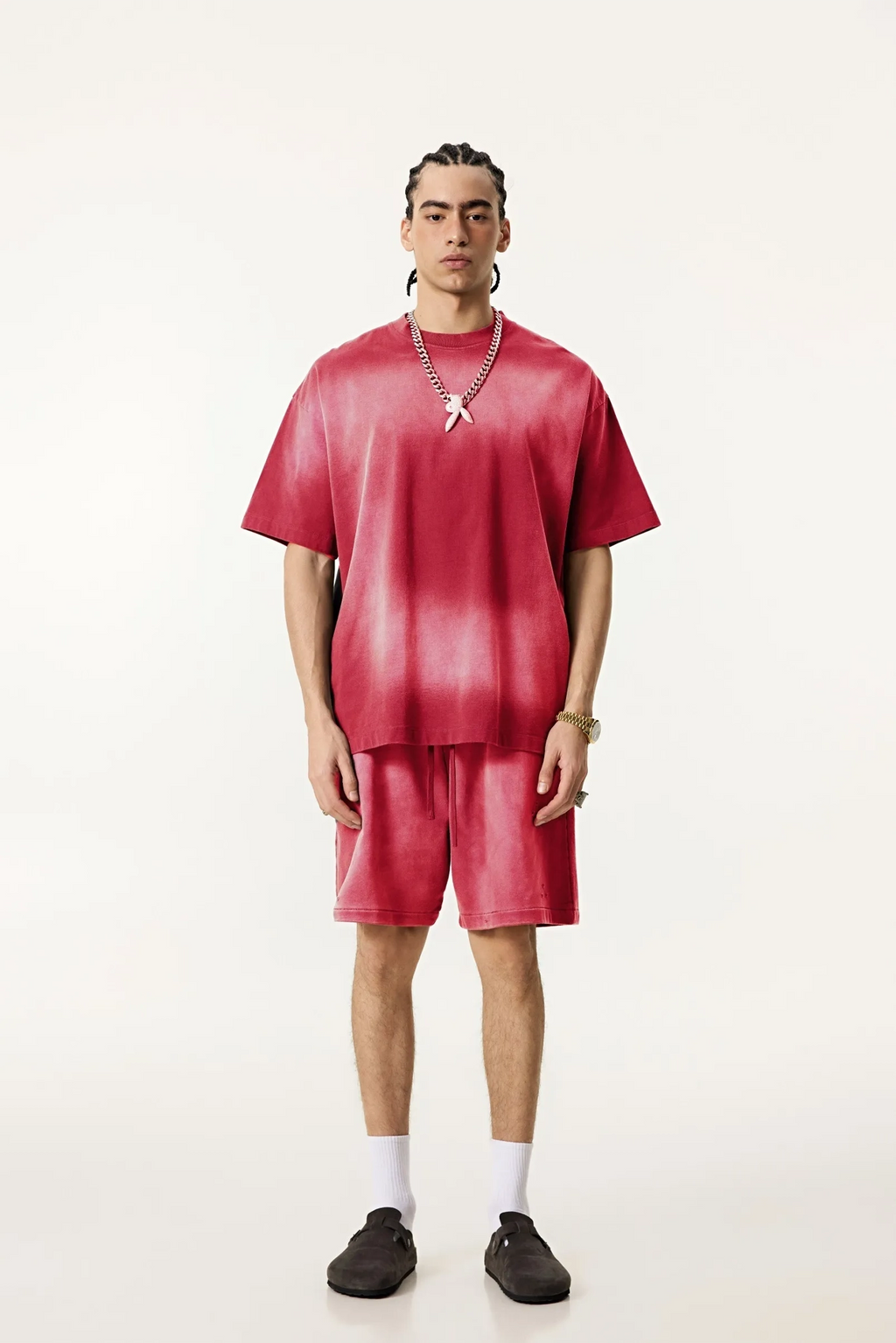 Person wearing a red tie-dye outfit on a white background