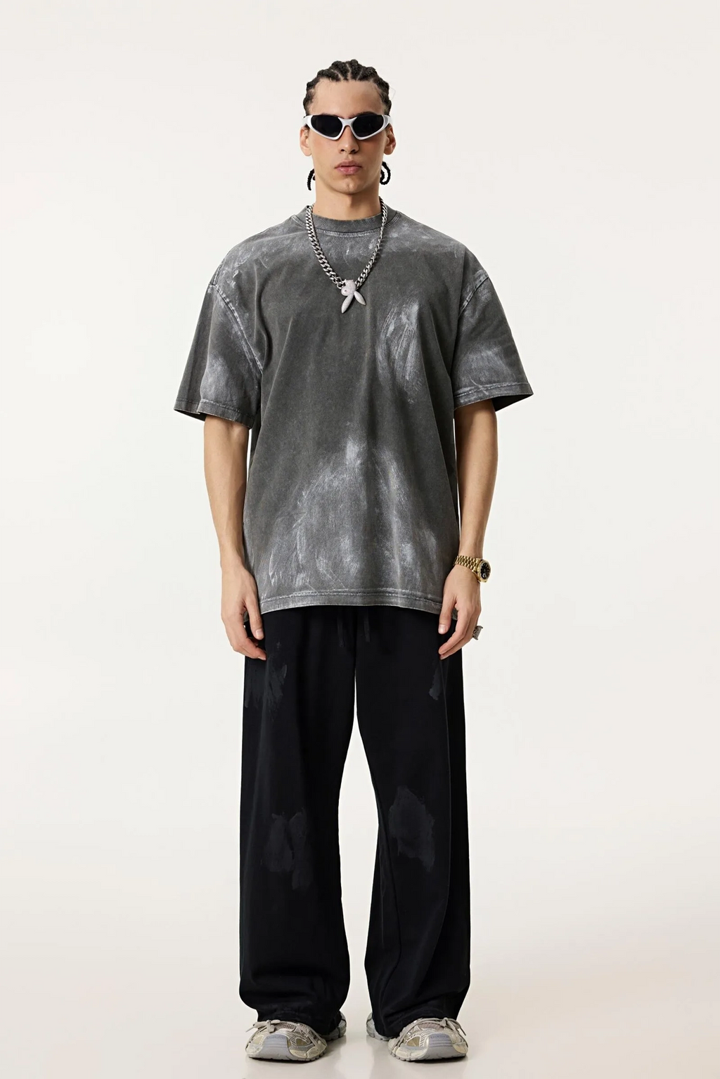 Person wearing a gray t-shirt and black pants on a white background