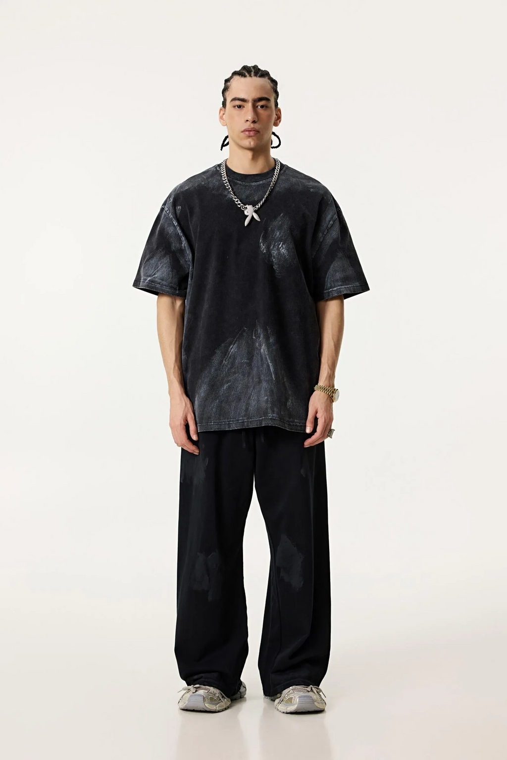Person wearing a black oversized t-shirt and pants on a white background