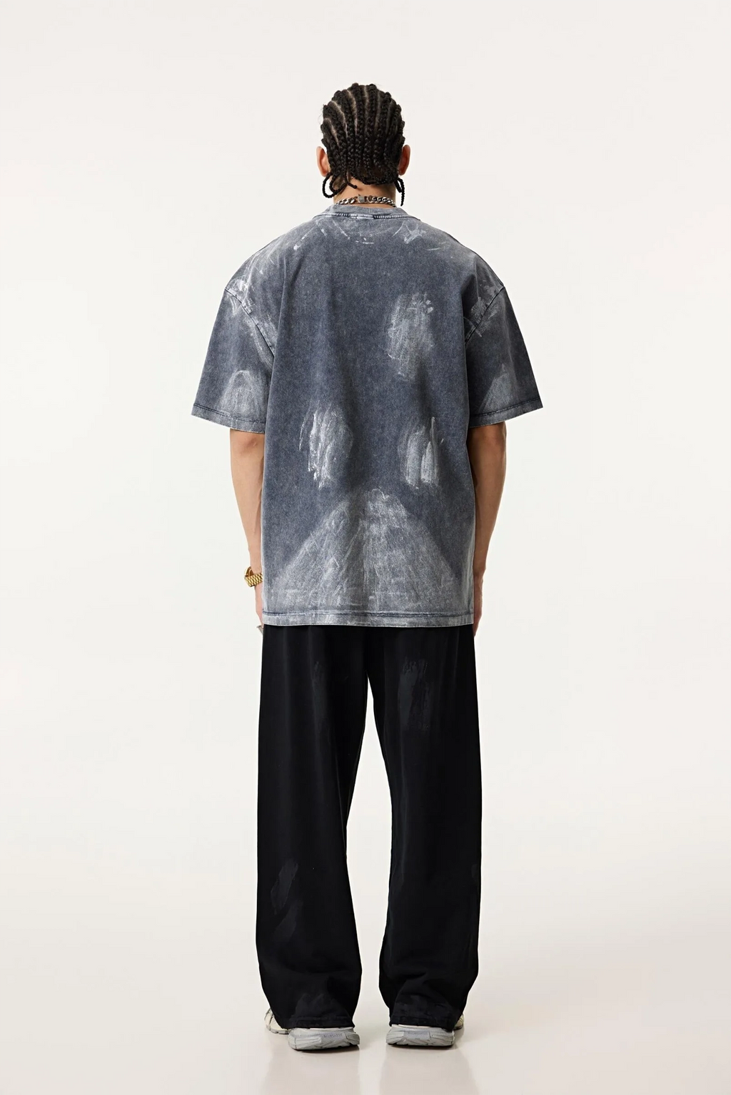 Person wearing a gray t-shirt with white patterns on a white background