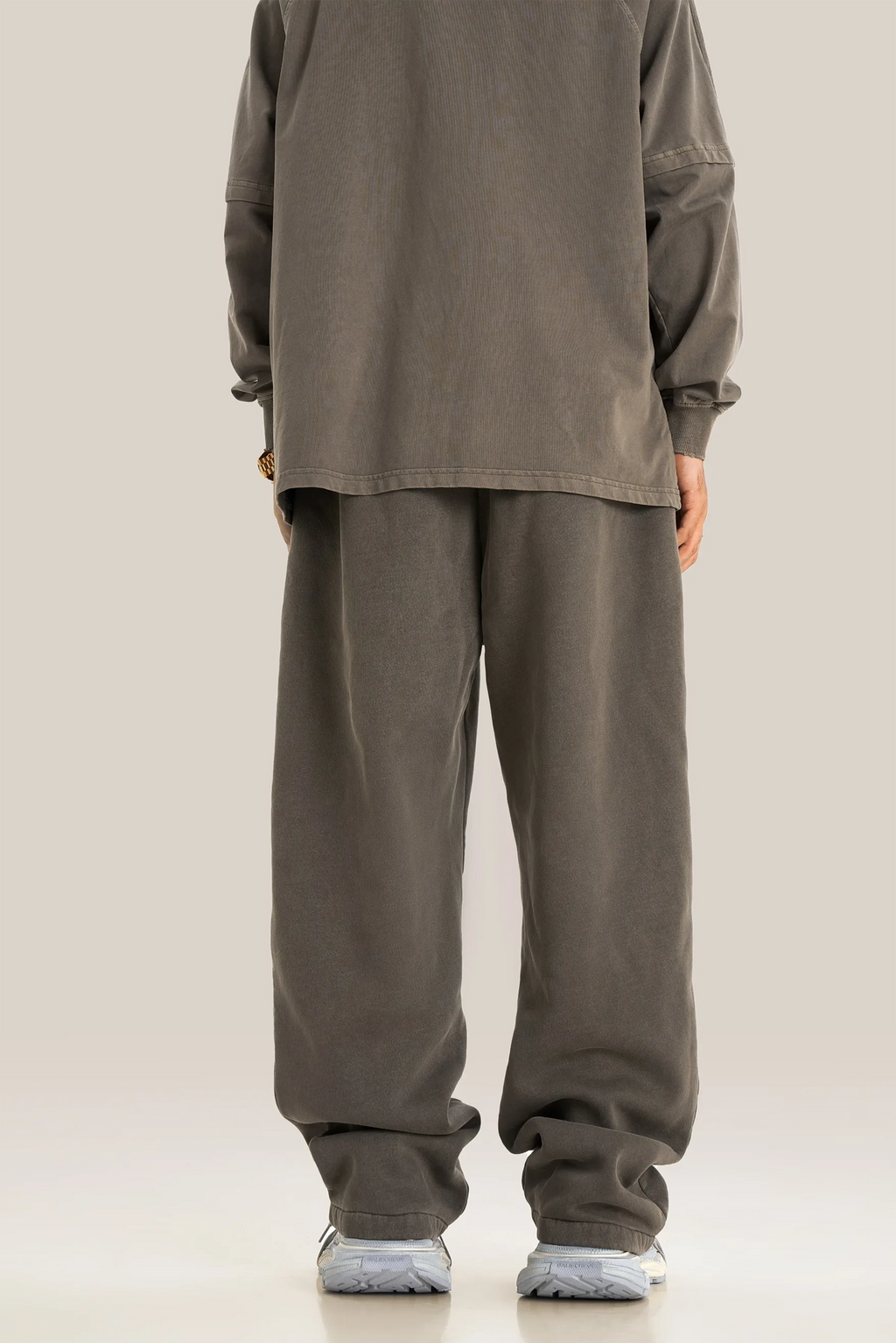 Person wearing a matching brown outfit with a shirt and pants on a plain background