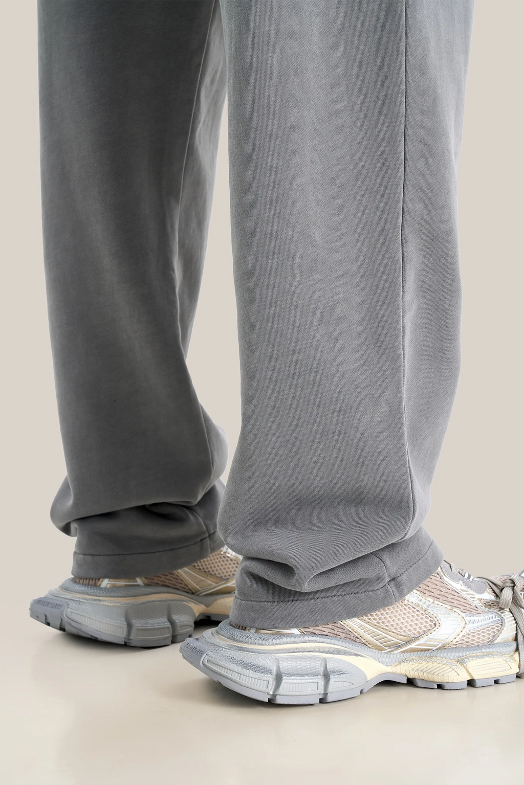 Gray sweatpants worn by a person on a beige background
