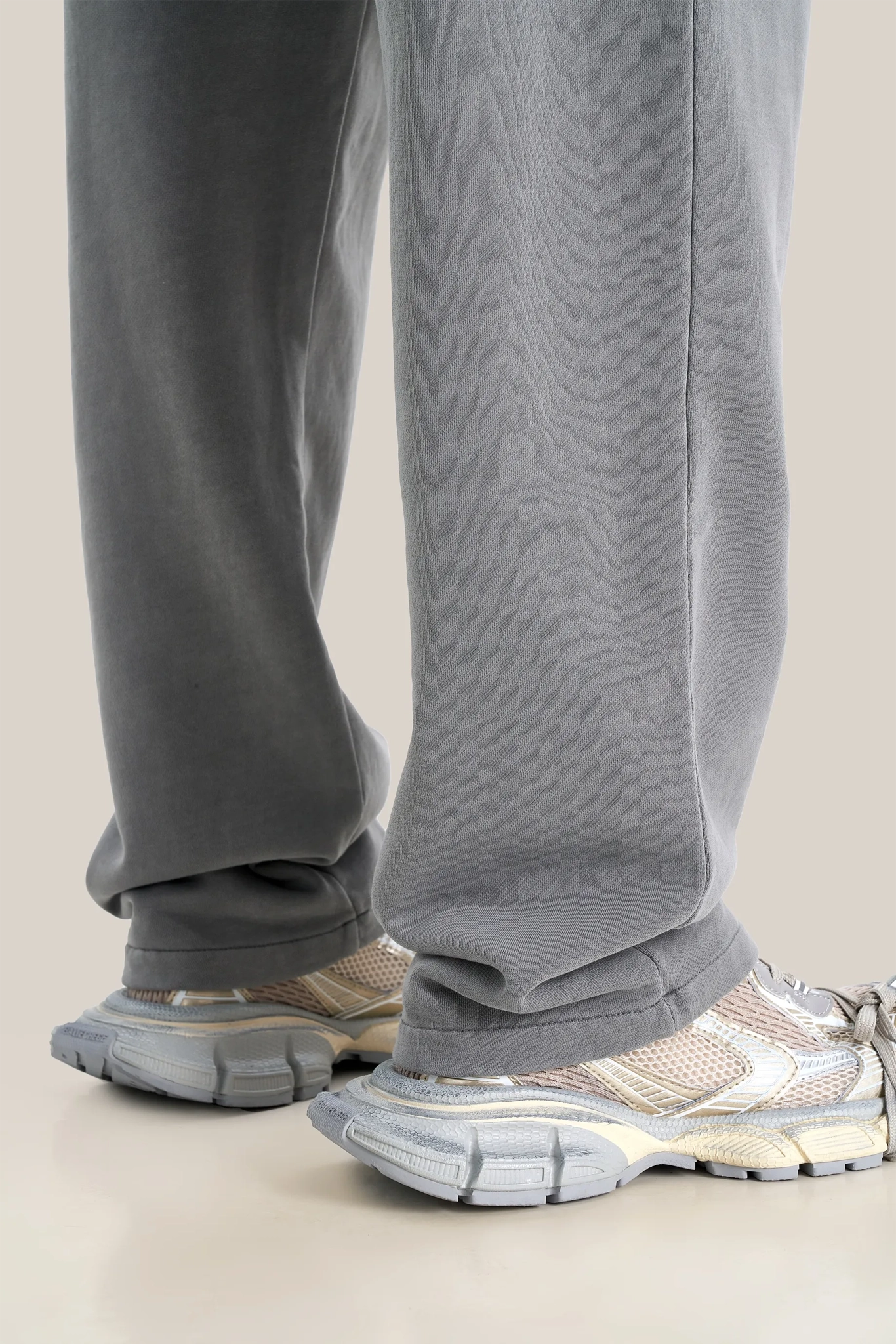 Gray sweatpants worn by a person on a beige background