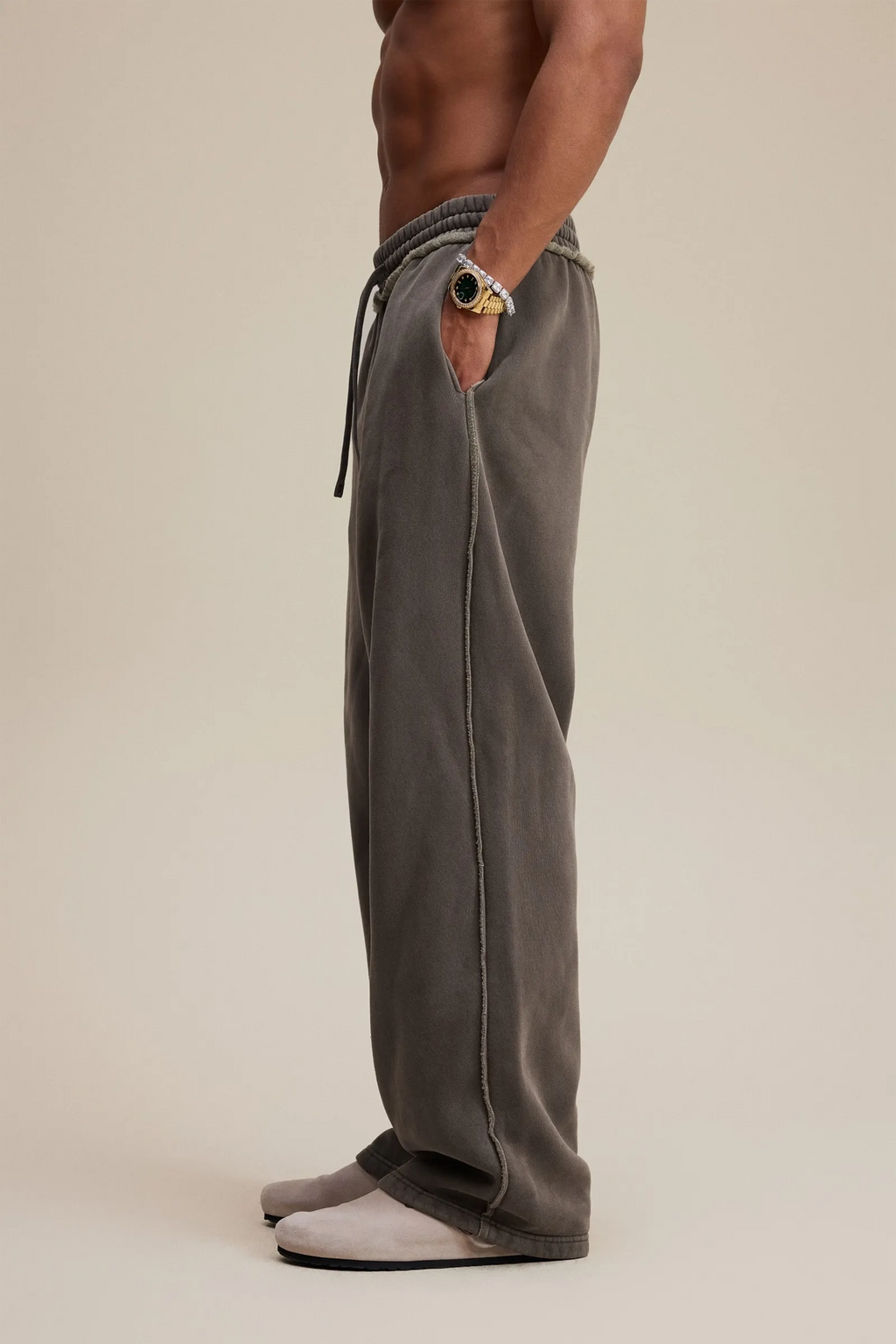 Person wearing gray sweatpants on a beige background