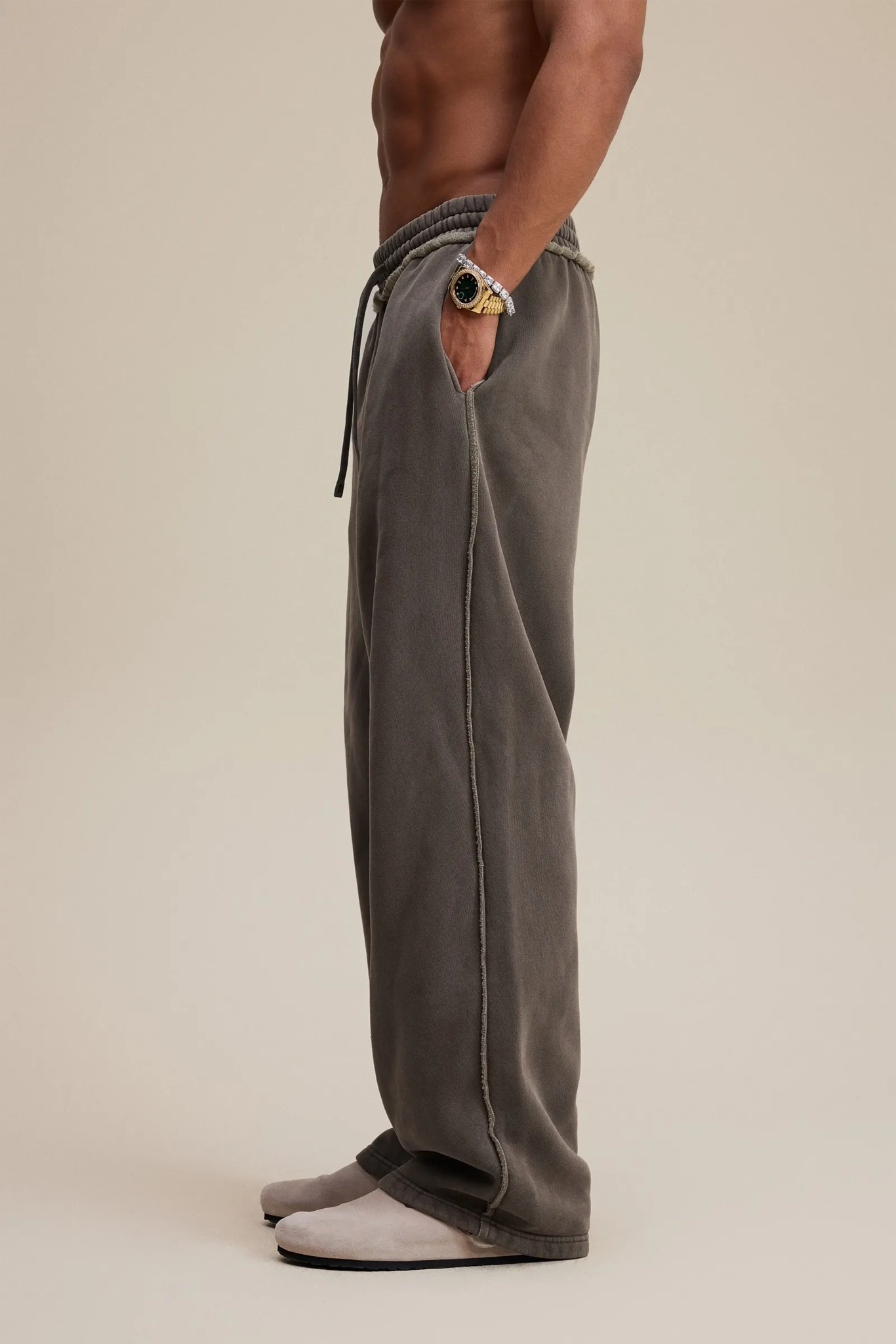 Person wearing gray sweatpants on a beige background