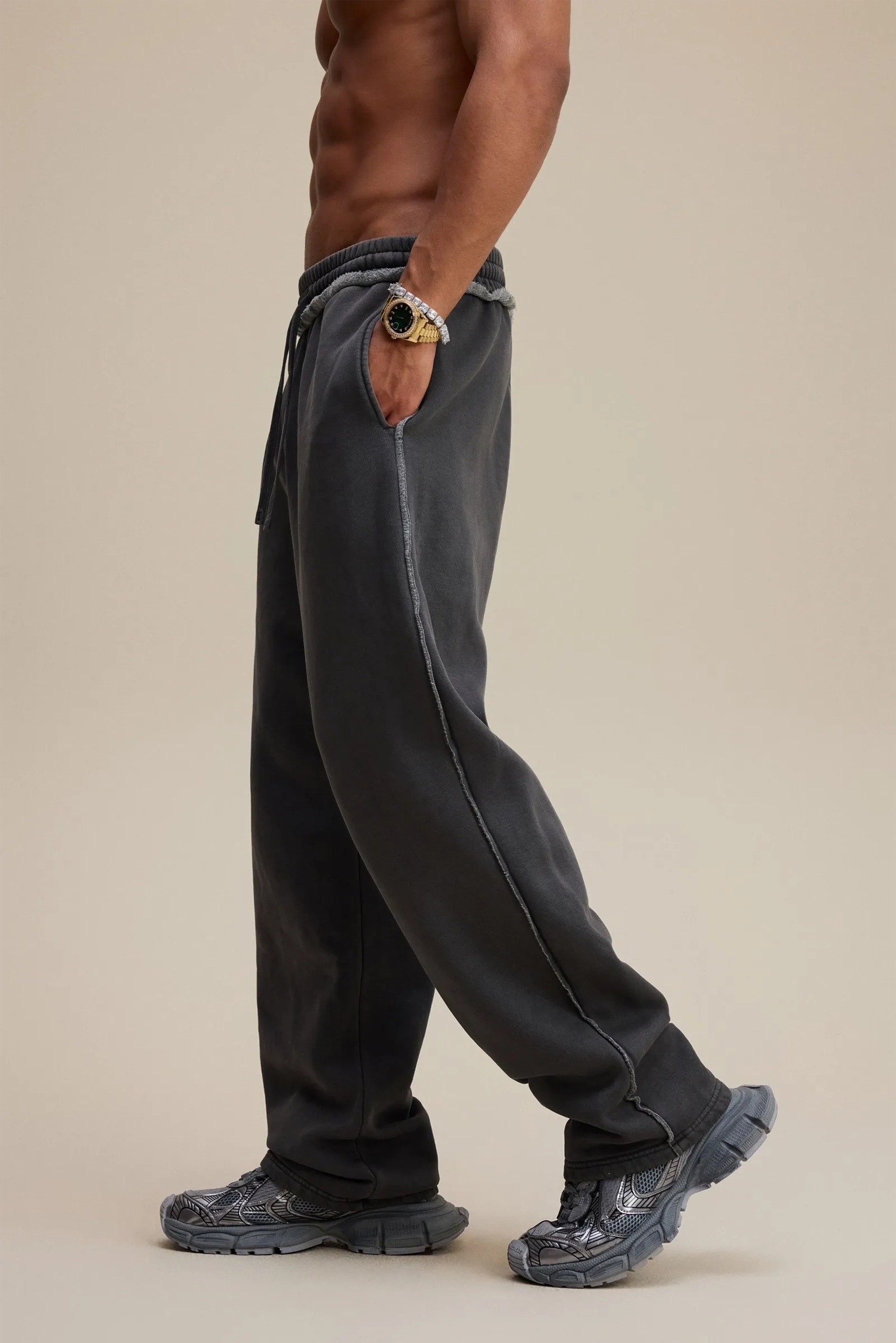 Person wearing black pants and shoes on a beige background