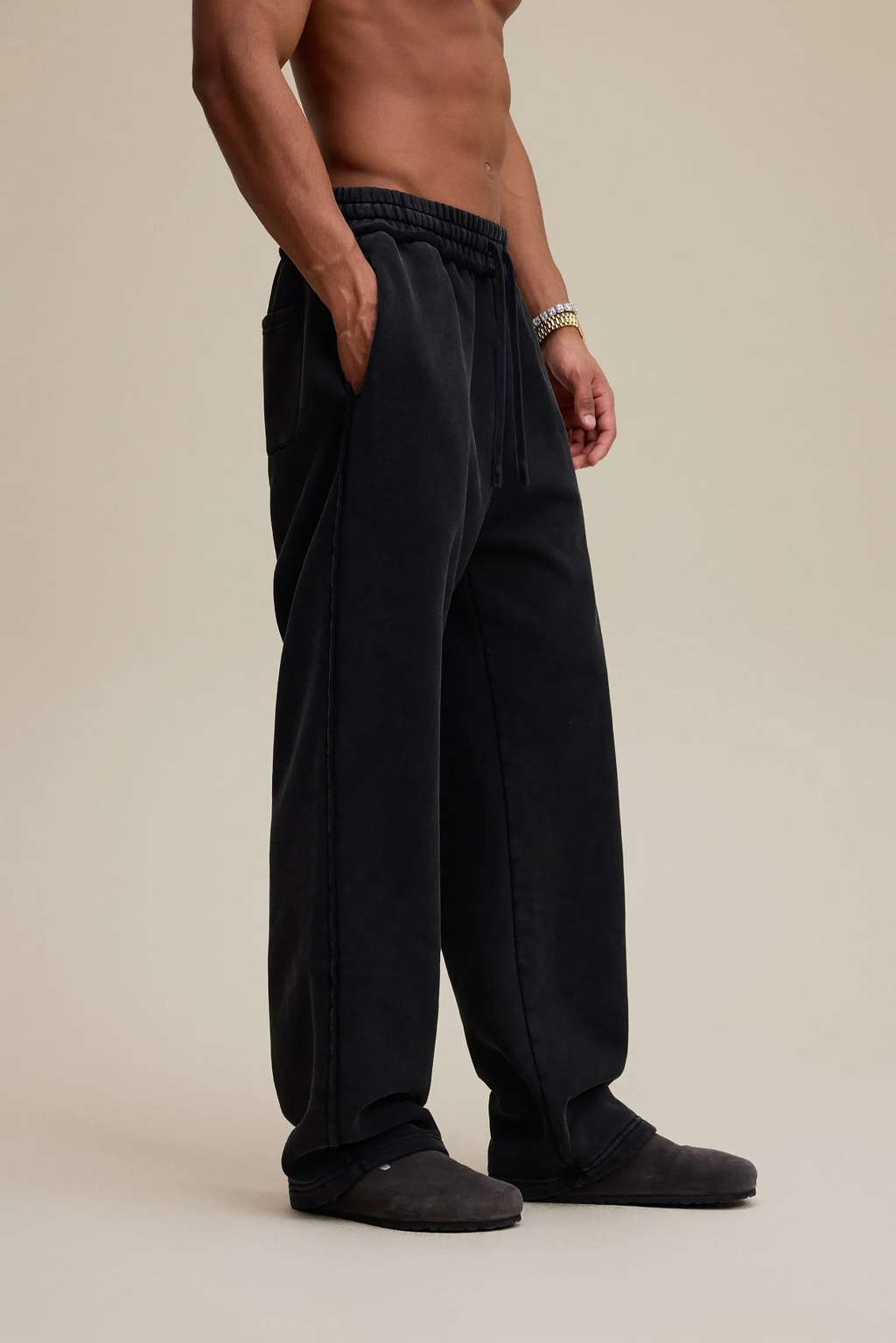 Person wearing black pants on a beige background