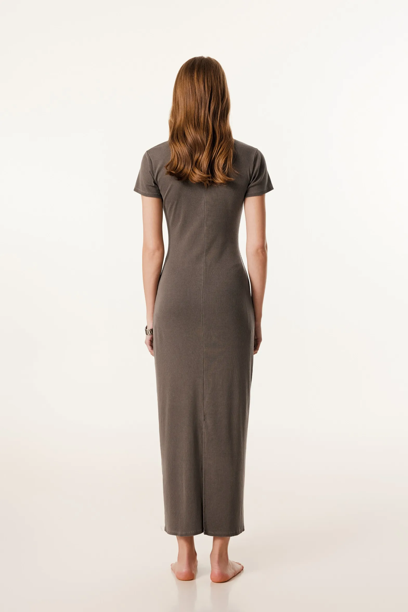 Woman wearing a long brown dress on a white background