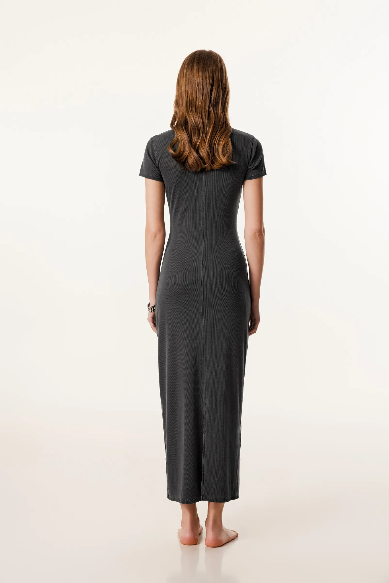 Woman wearing a black dress from behind on a white background