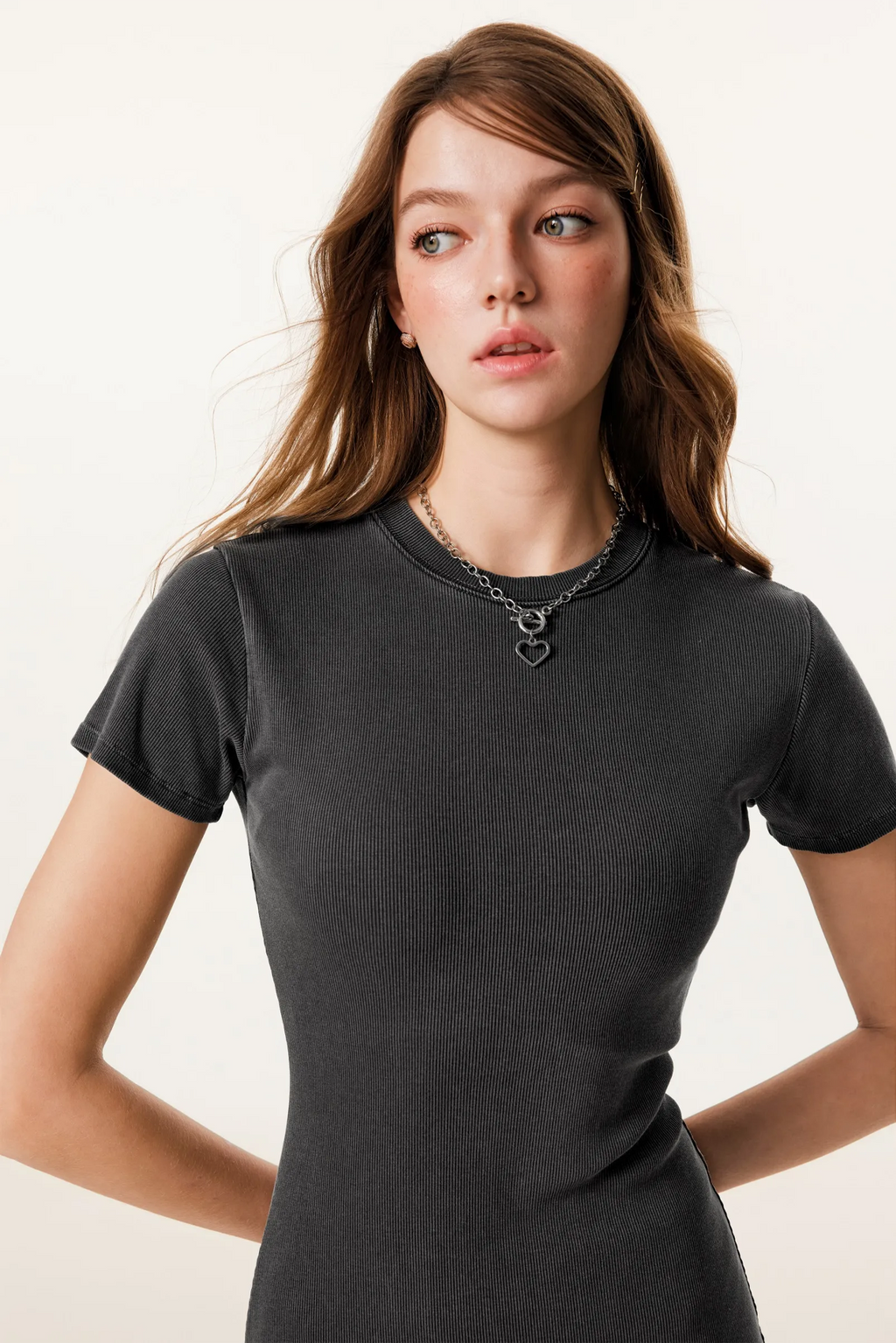 Woman wearing a black t-shirt with a plain background