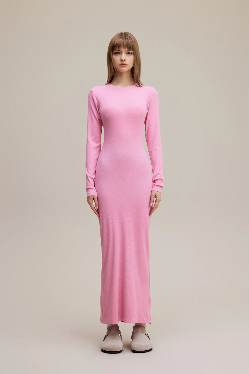 Woman wearing a pink dress on a beige background