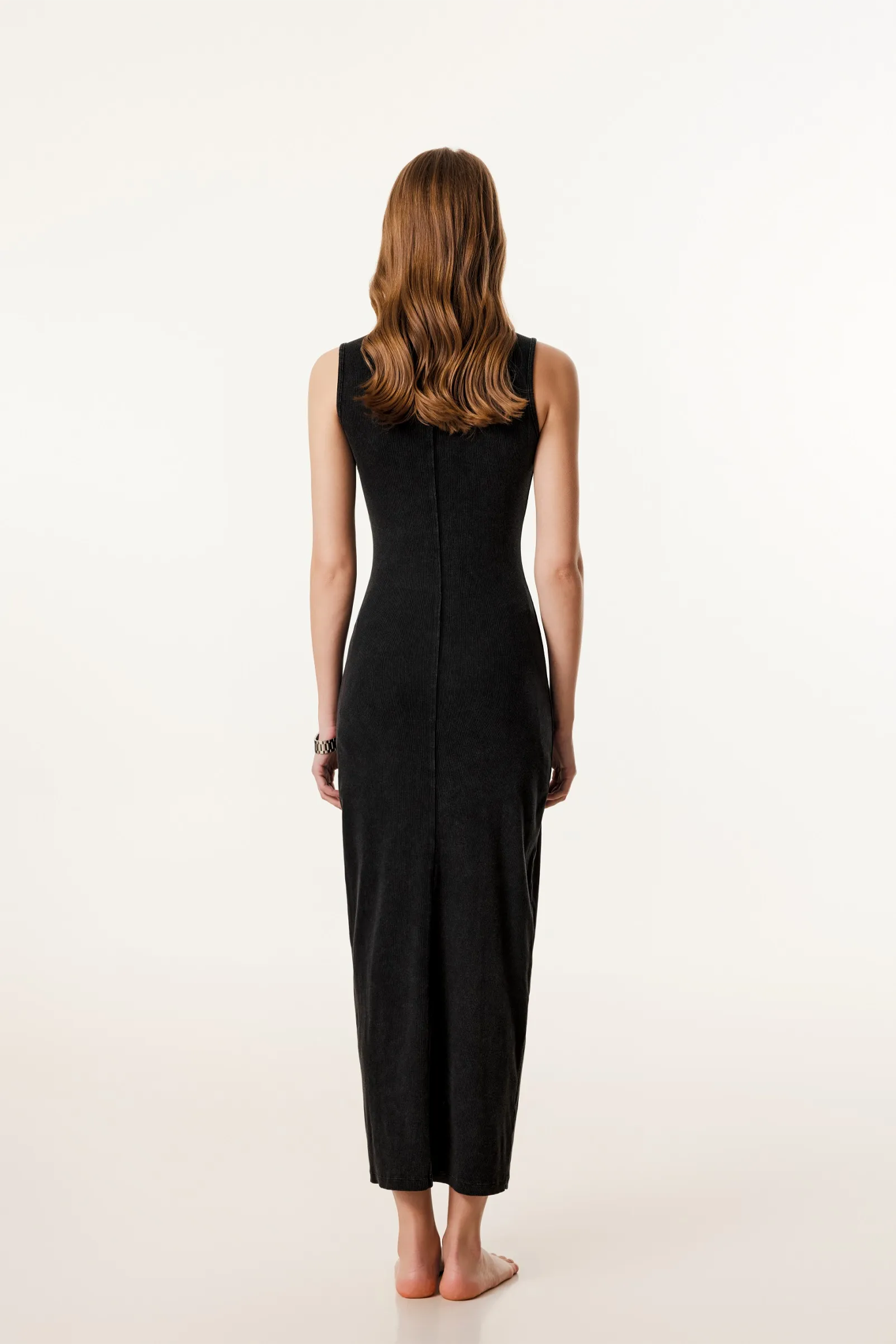 Woman wearing a black sleeveless jumpsuit on a white background