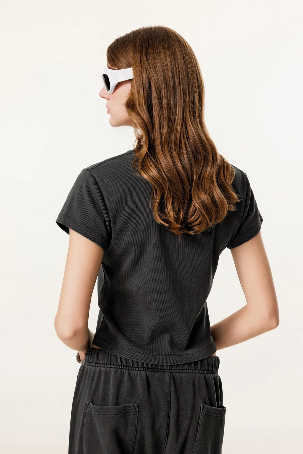 Person wearing a black outfit on a plain background