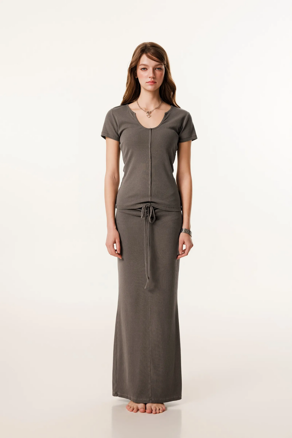 Woman wearing a long brown dress with a white background