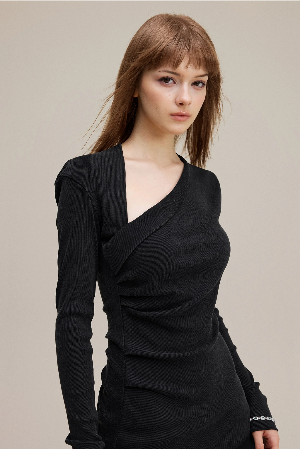 Woman wearing a black dress against a plain background