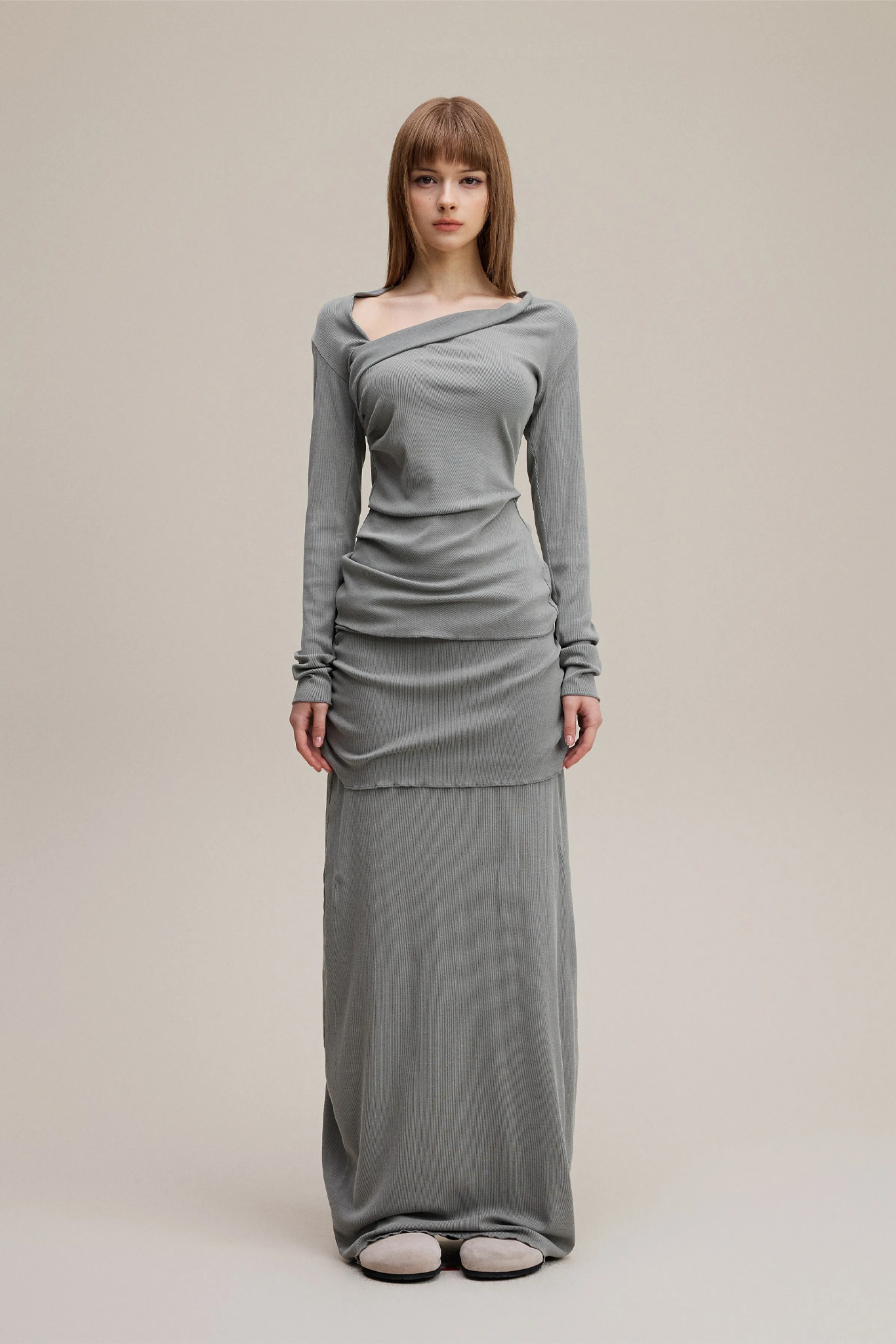 Woman wearing a gray dress on a plain background