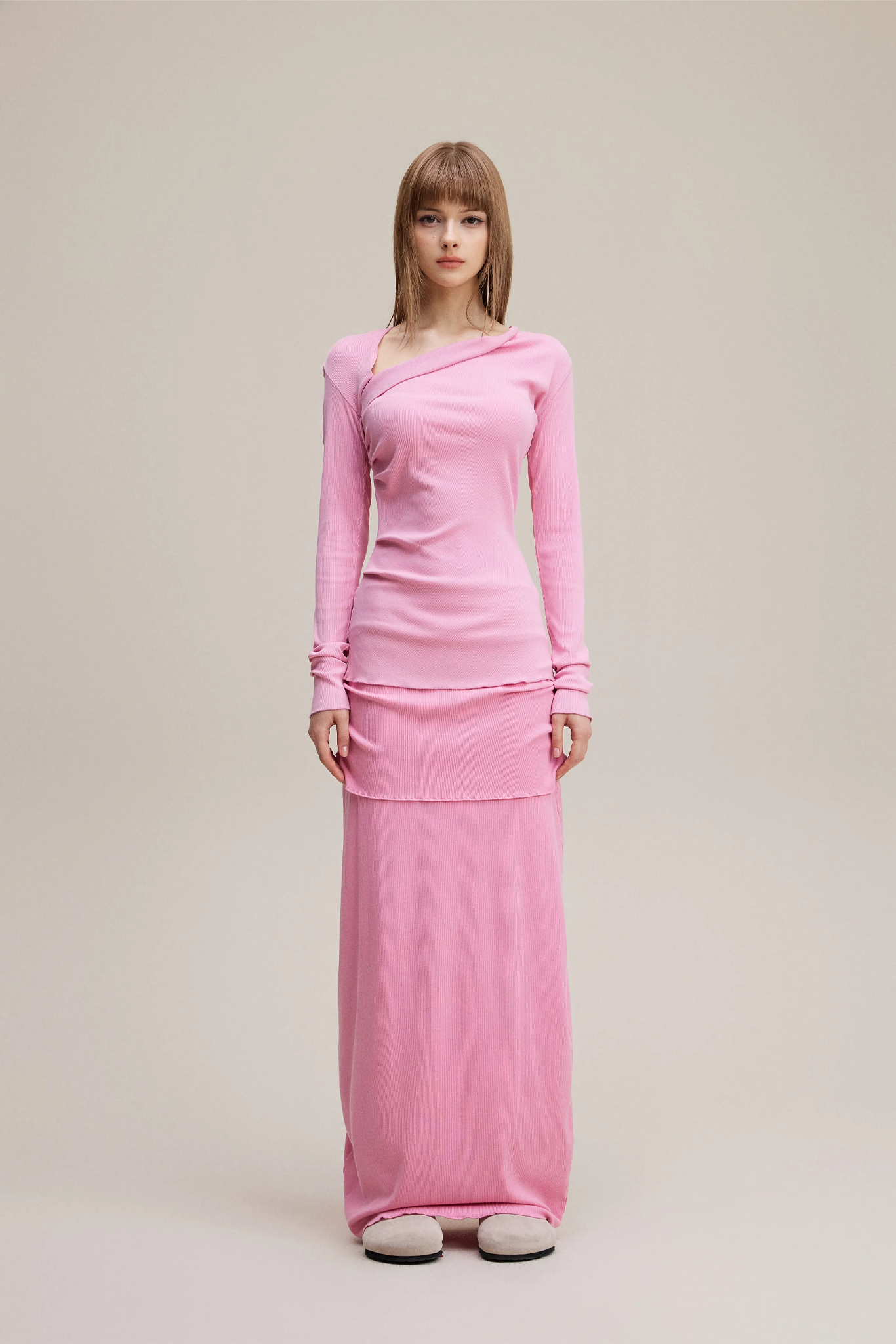 Woman wearing a pink dress against a plain background