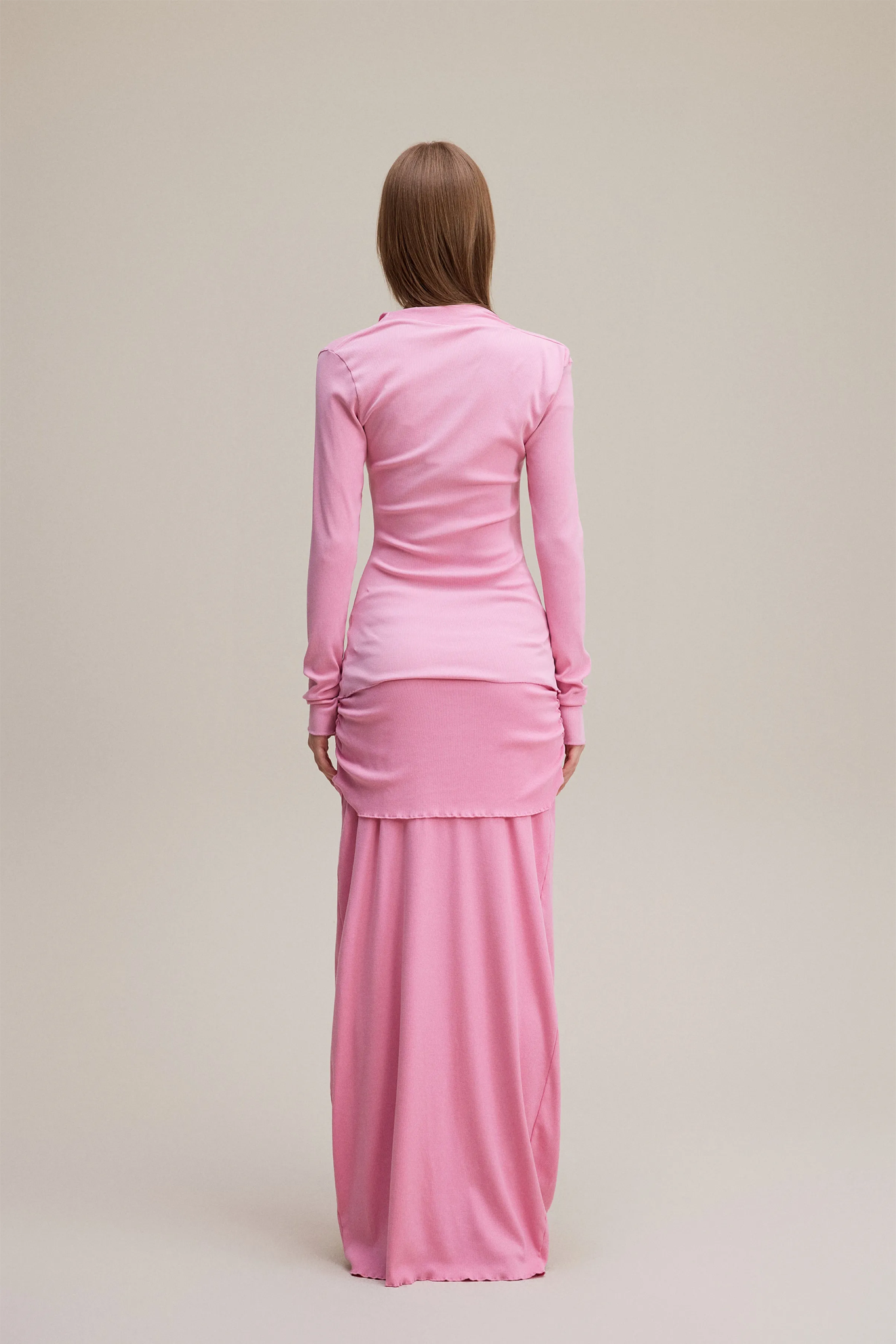 Woman wearing a pink outfit on a beige background