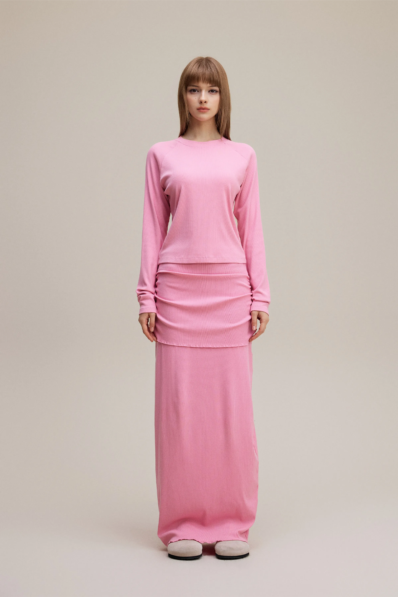 Woman wearing a pink outfit on a beige background