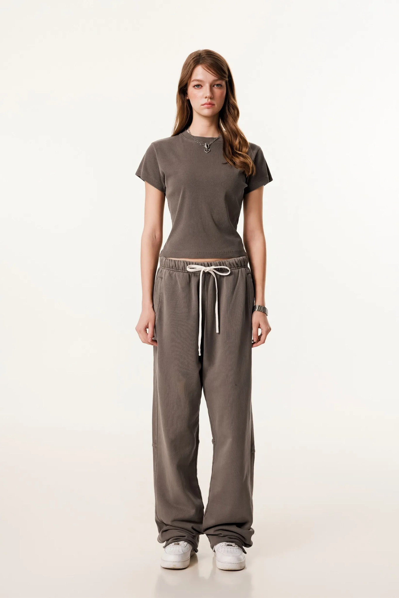 Woman wearing a brown t-shirt and pants on a white background