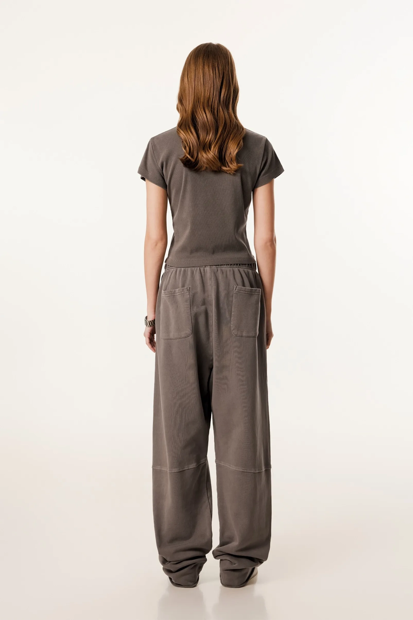 Person wearing a brown jumpsuit on a white background