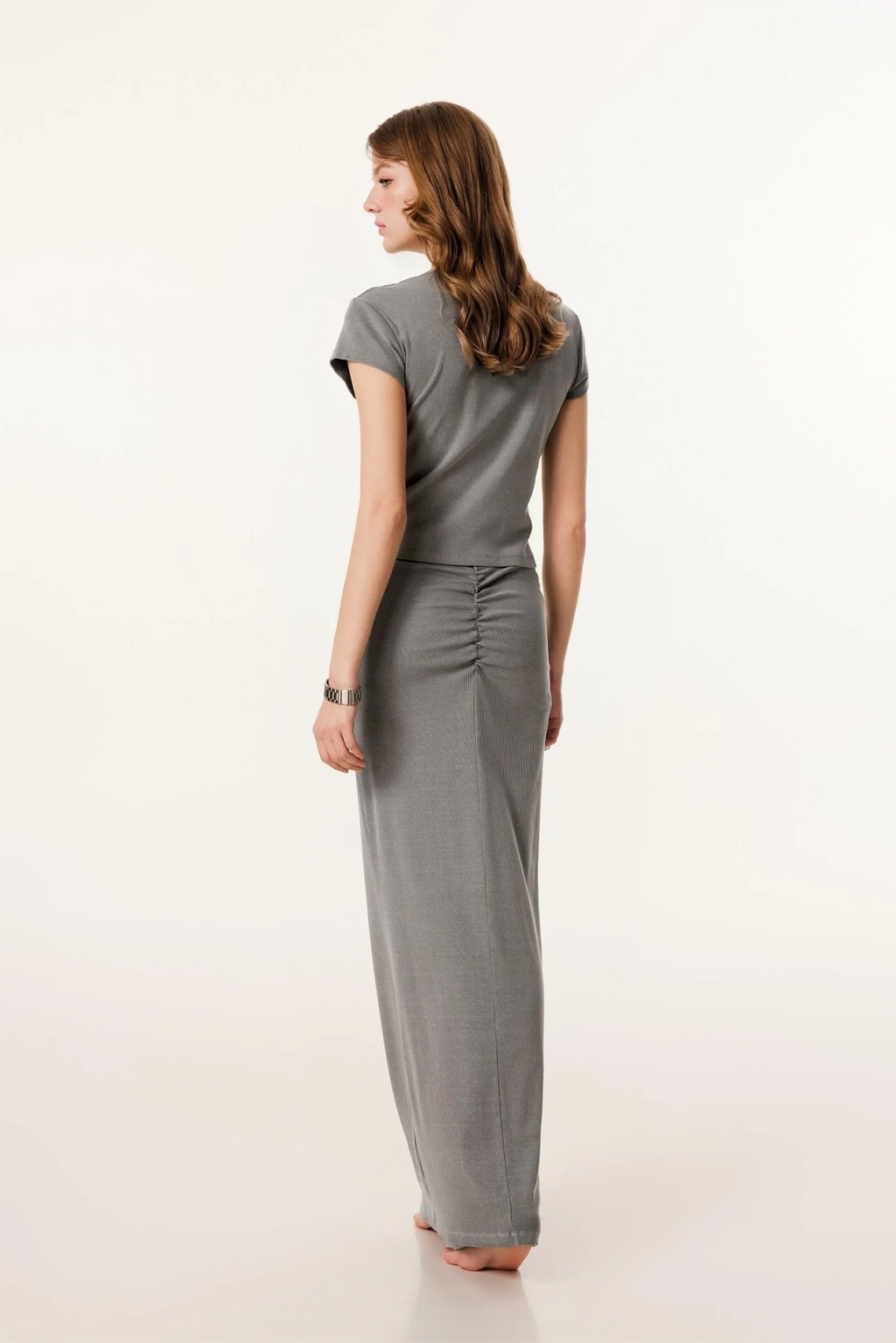 Woman wearing a gray jumpsuit on a white background