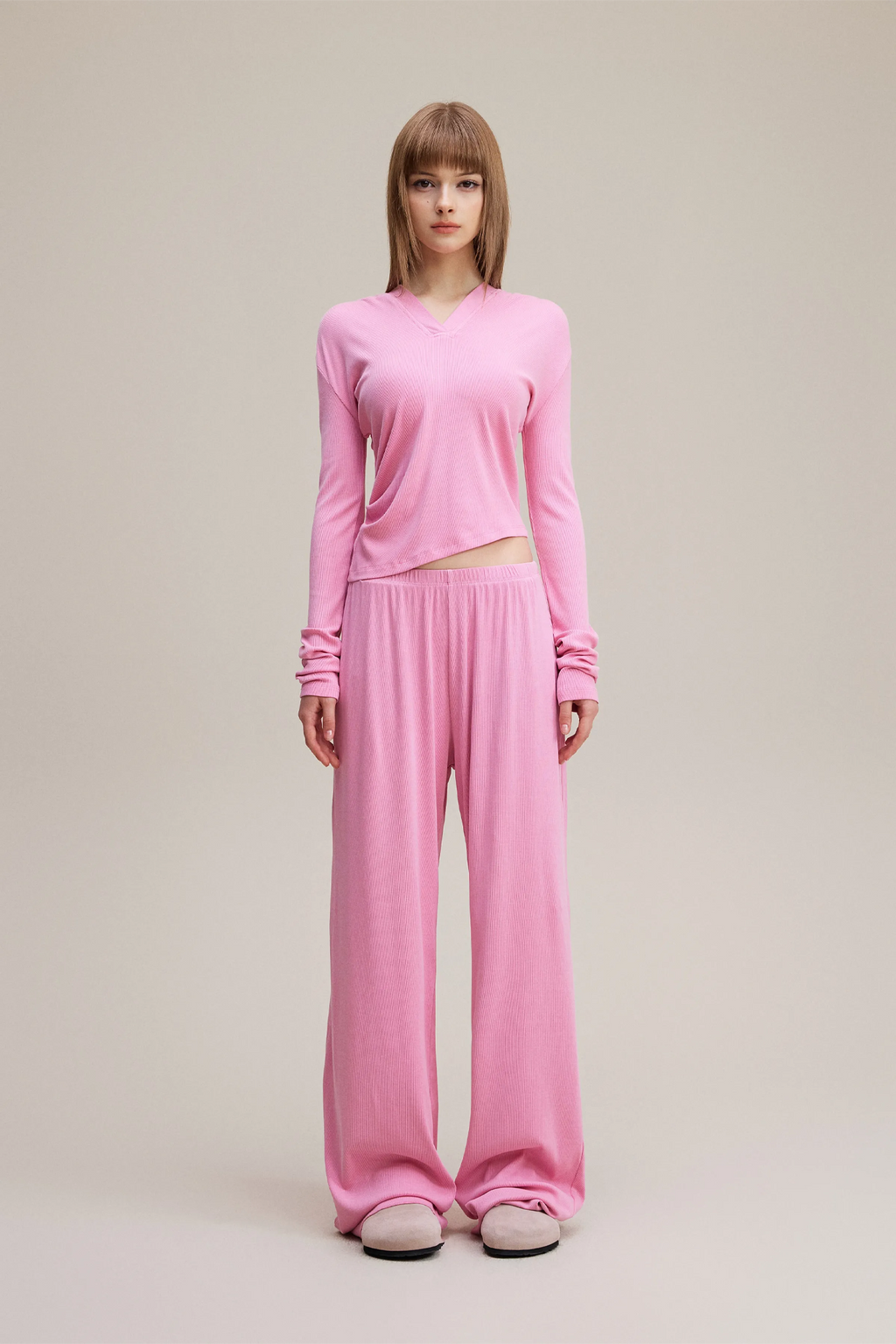 Person wearing a pink outfit on a plain background