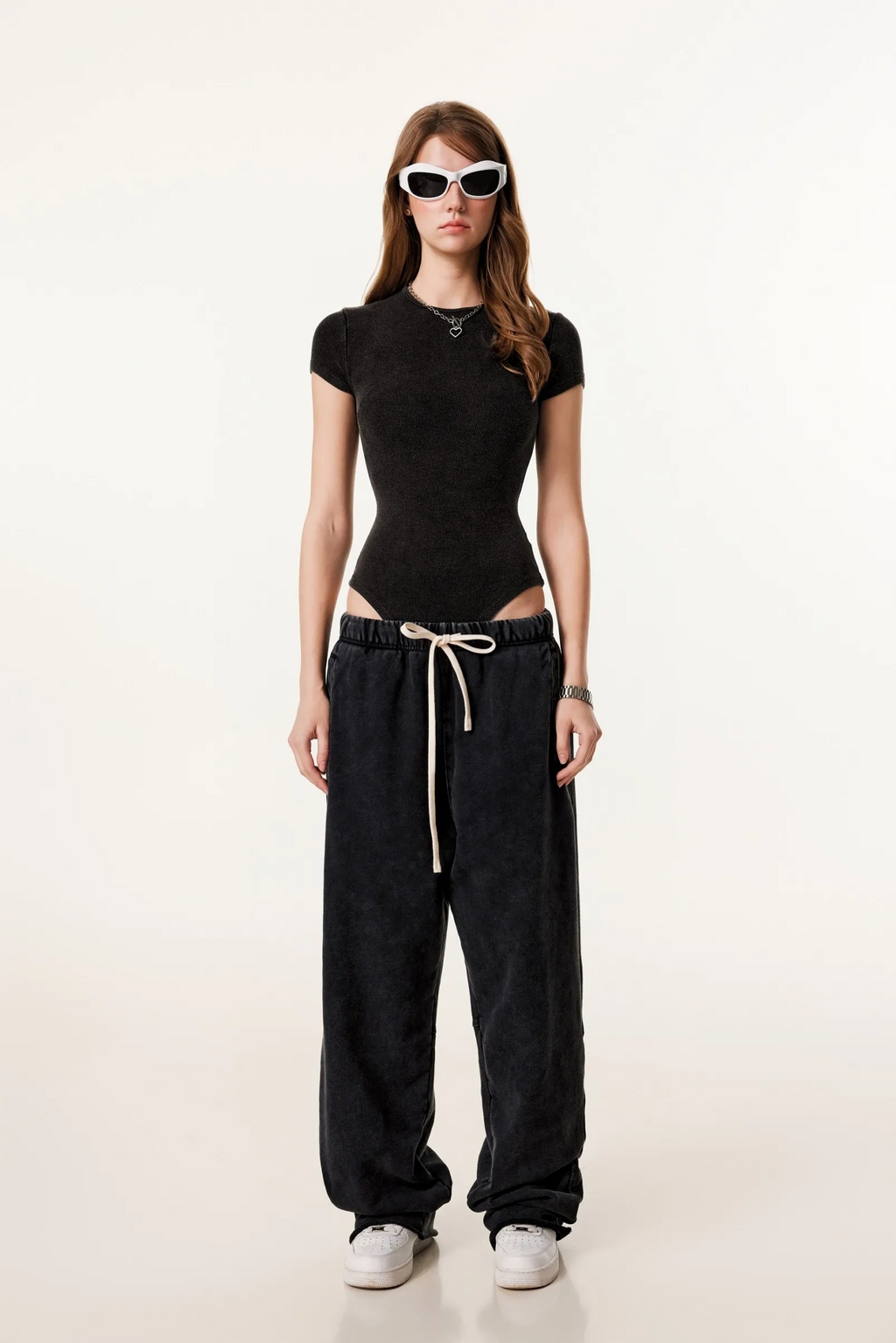 Person wearing a black outfit with a white background