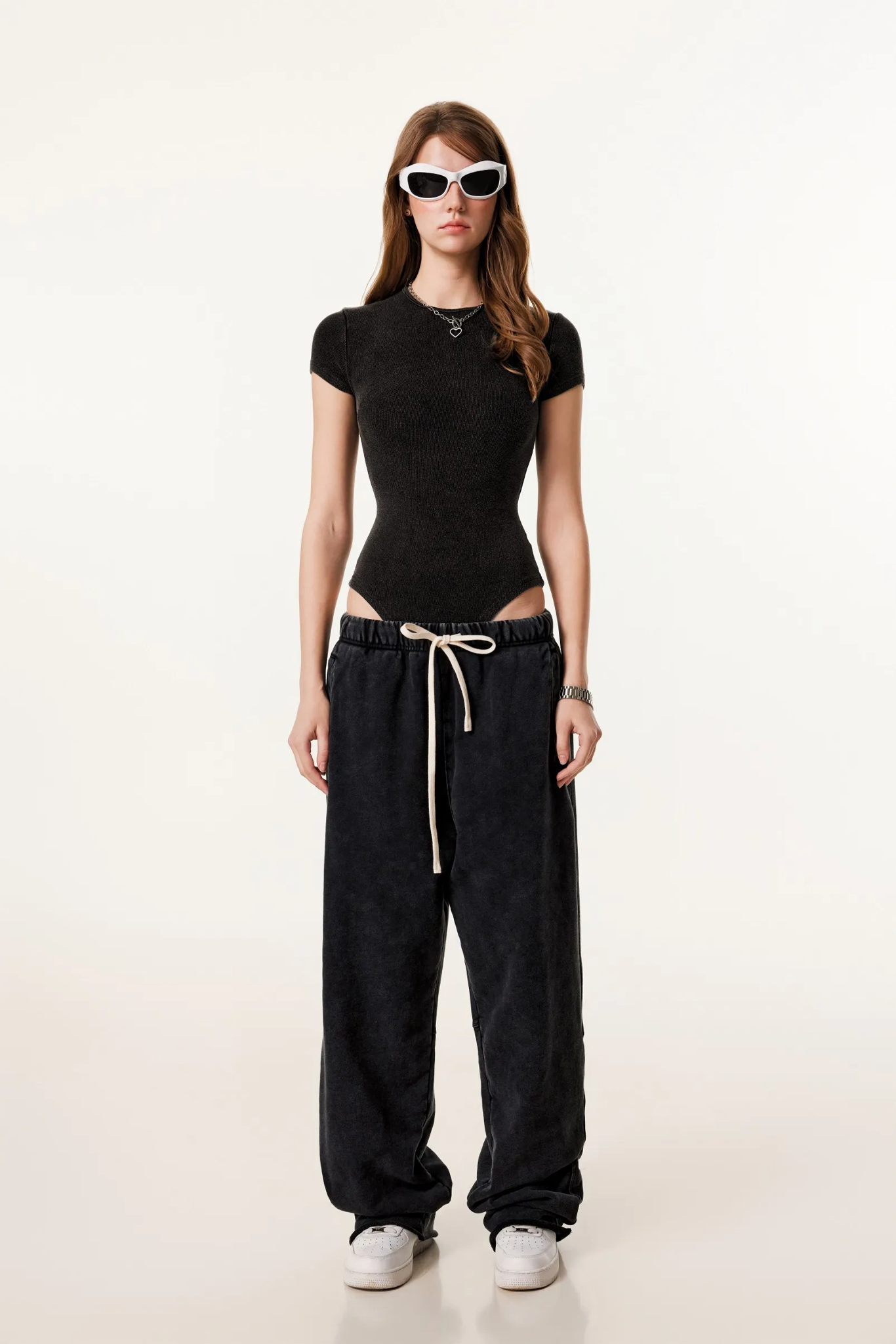 Person wearing a black outfit with a white background