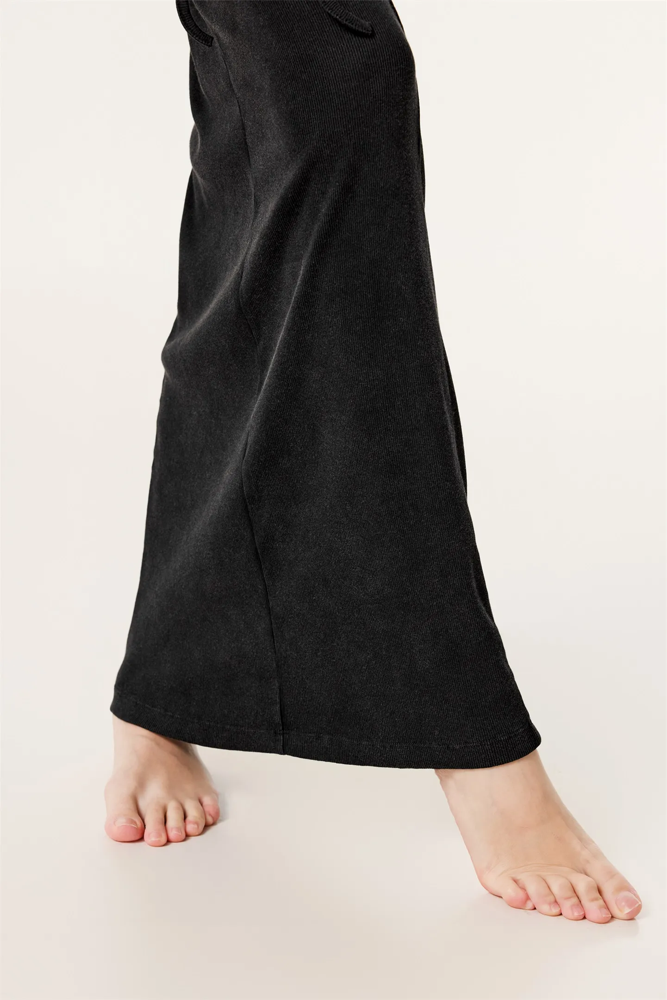 Black pants worn by a person on a plain background