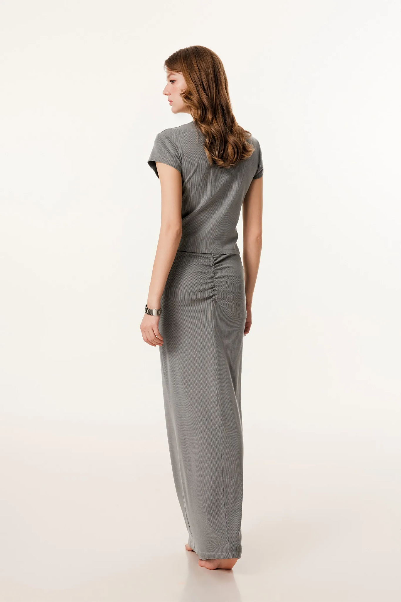 Woman wearing a gray jumpsuit on a white background