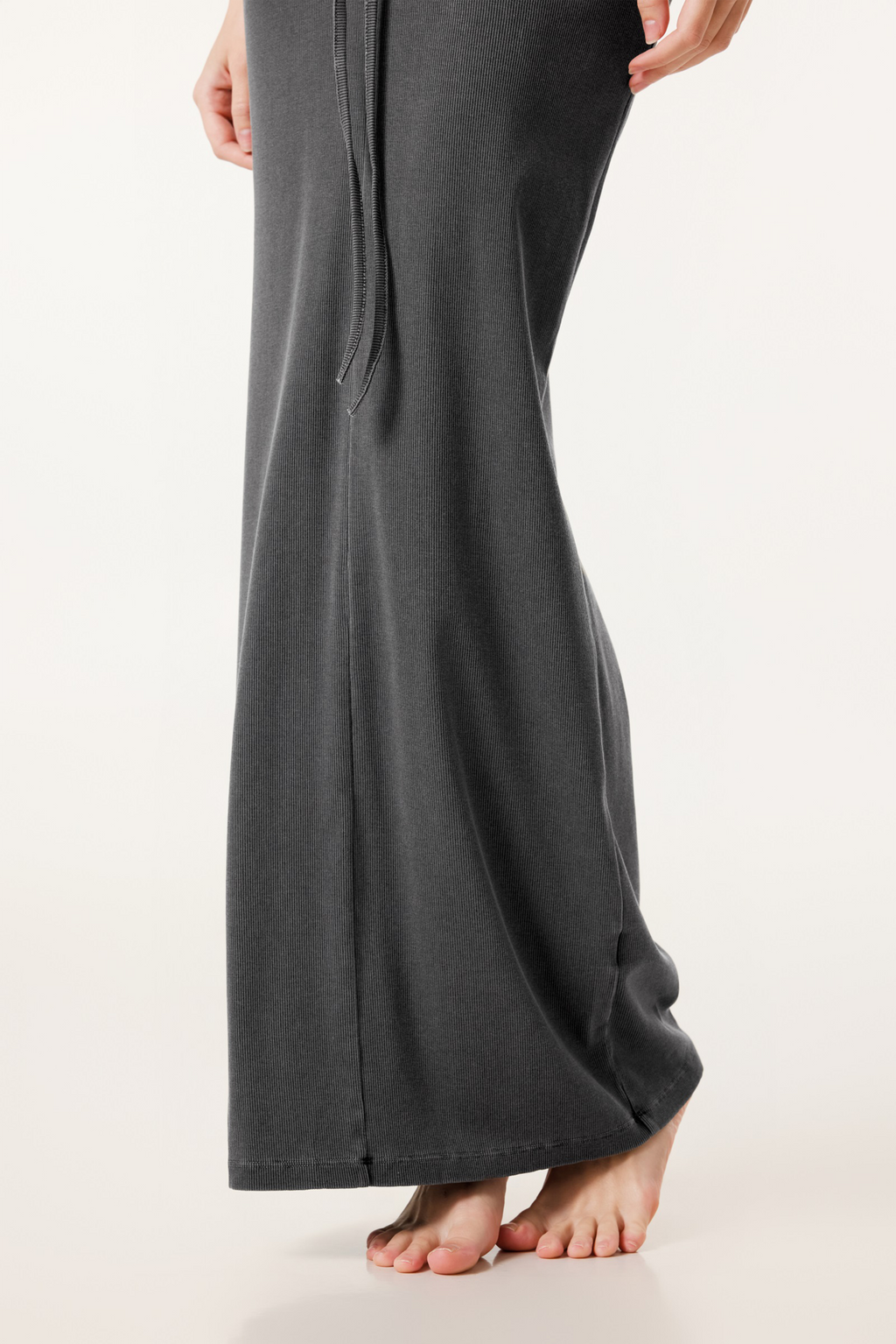 Dark gray wide-leg pants worn by a person on a white background