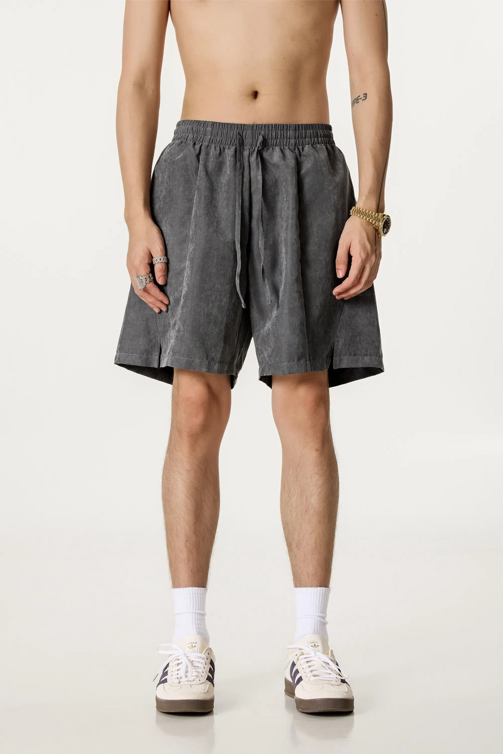 Person wearing gray shorts on a white background