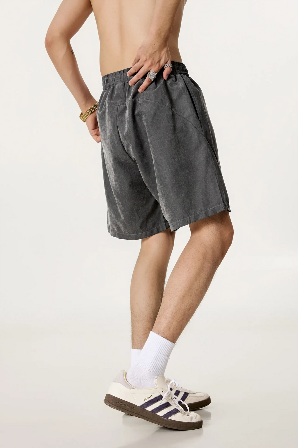 Person wearing gray shorts and white socks on a plain background