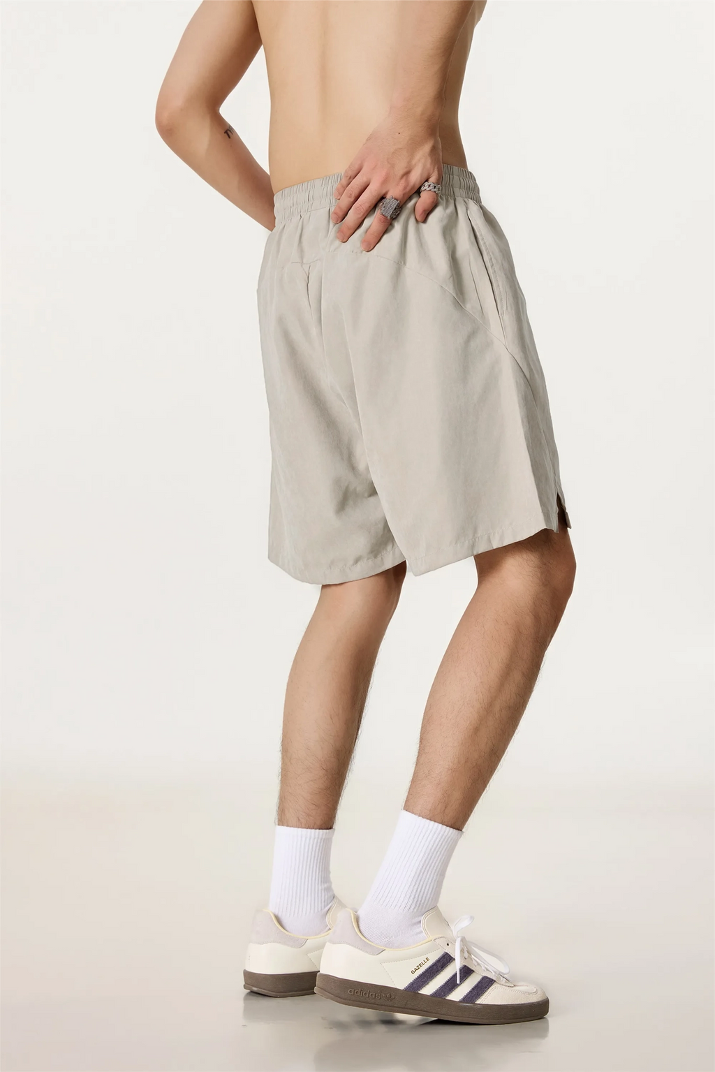 Person wearing beige shorts on a plain background
