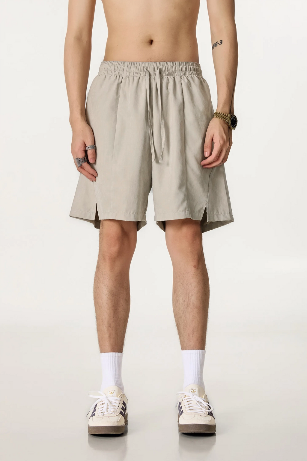 Person wearing beige shorts on a plain background