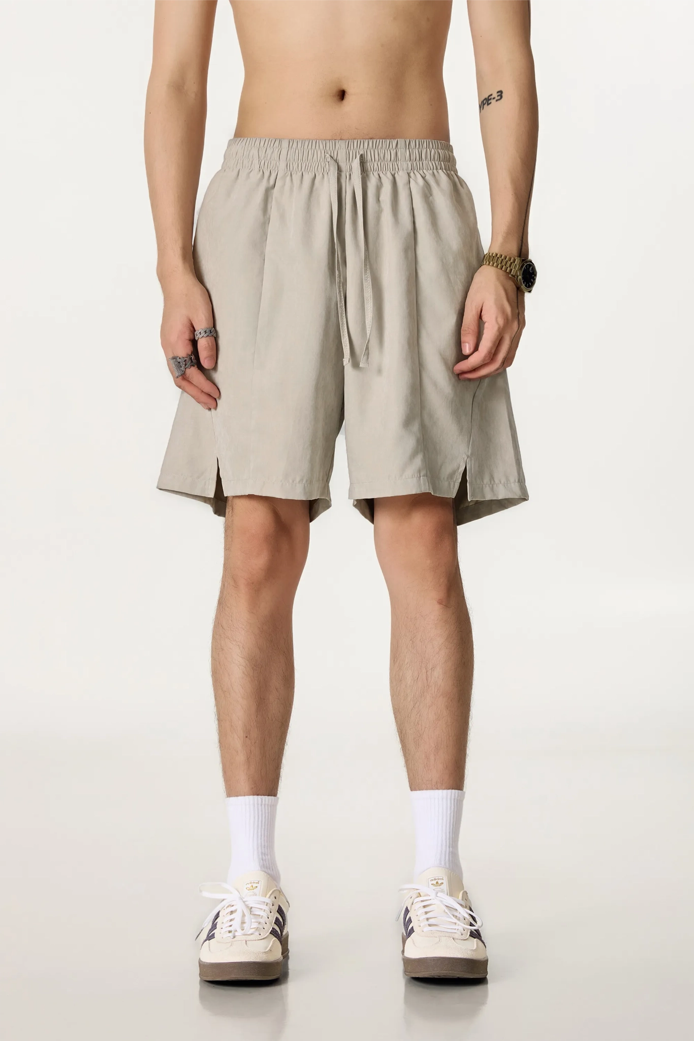 Person wearing beige shorts on a plain background