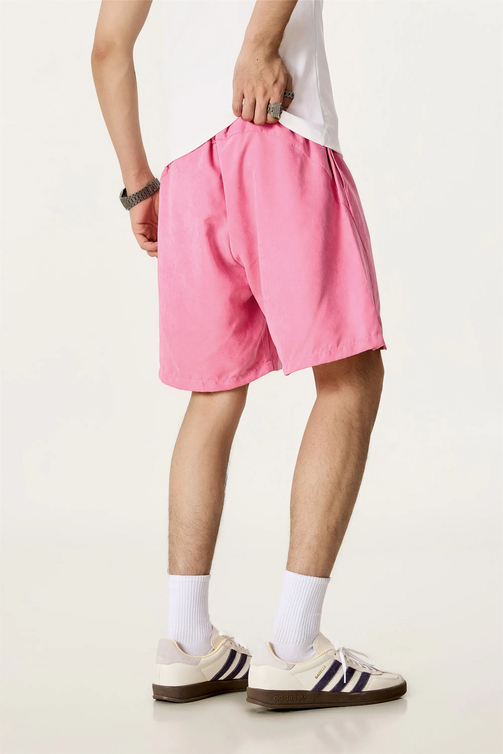 Person wearing pink shorts and white socks on a plain background