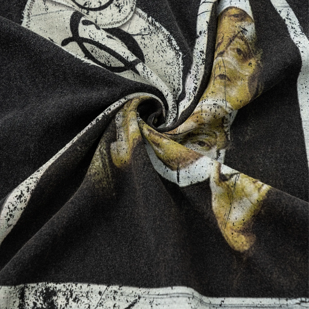 Close-up of black fabric with a patterned yellow and white scarf draped over it.