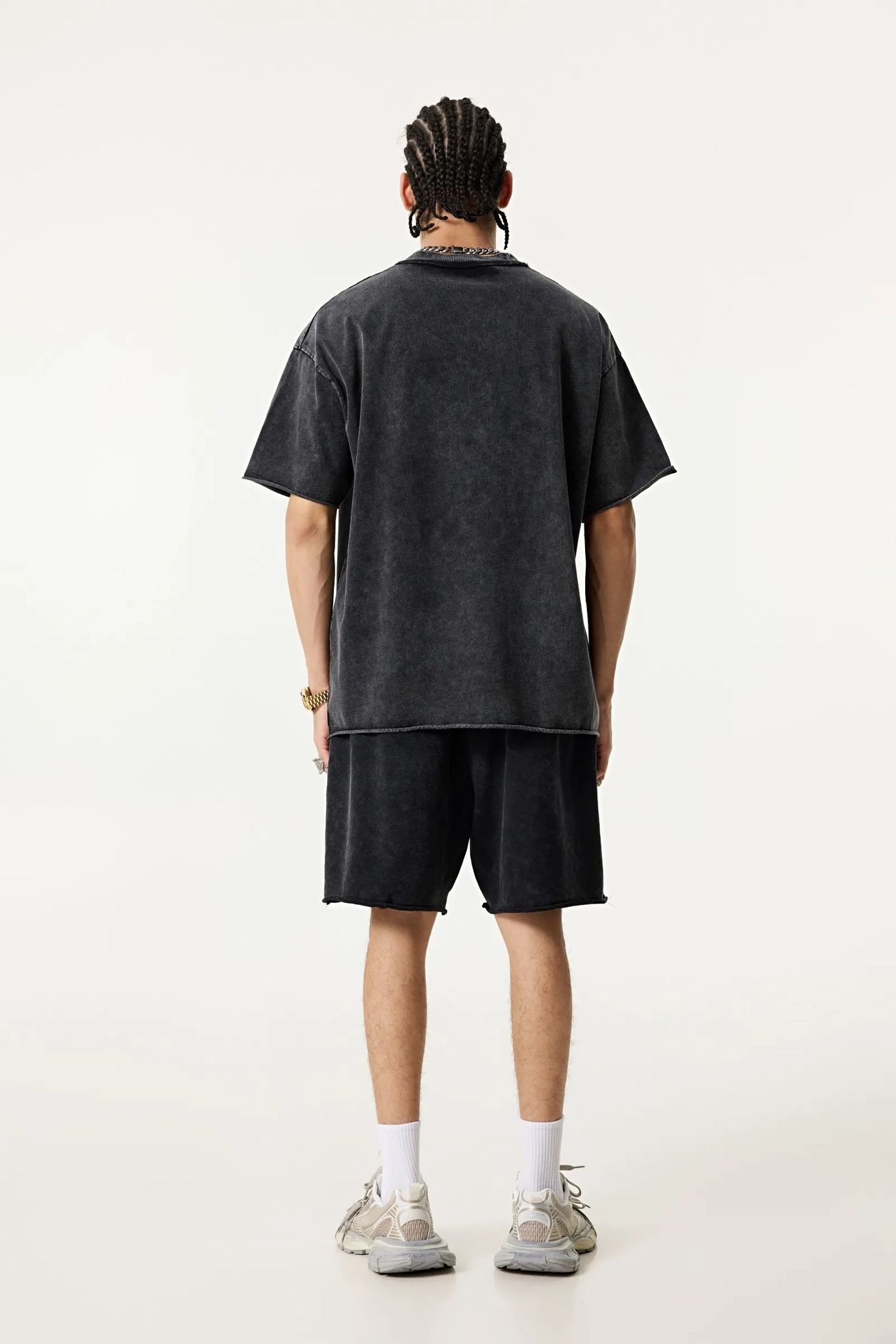 Person wearing a black t-shirt and shorts set on a white background