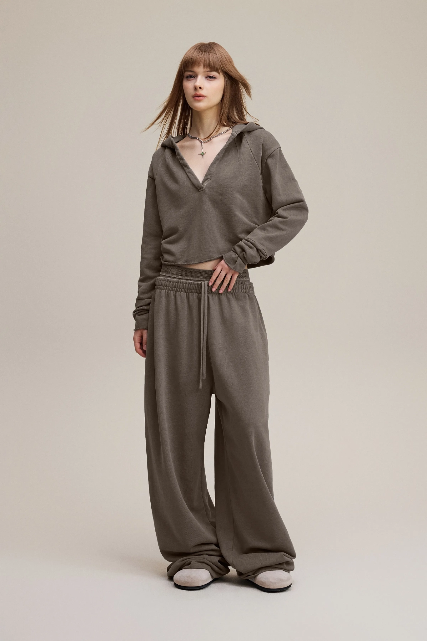 Woman wearing a brown tracksuit on a plain background