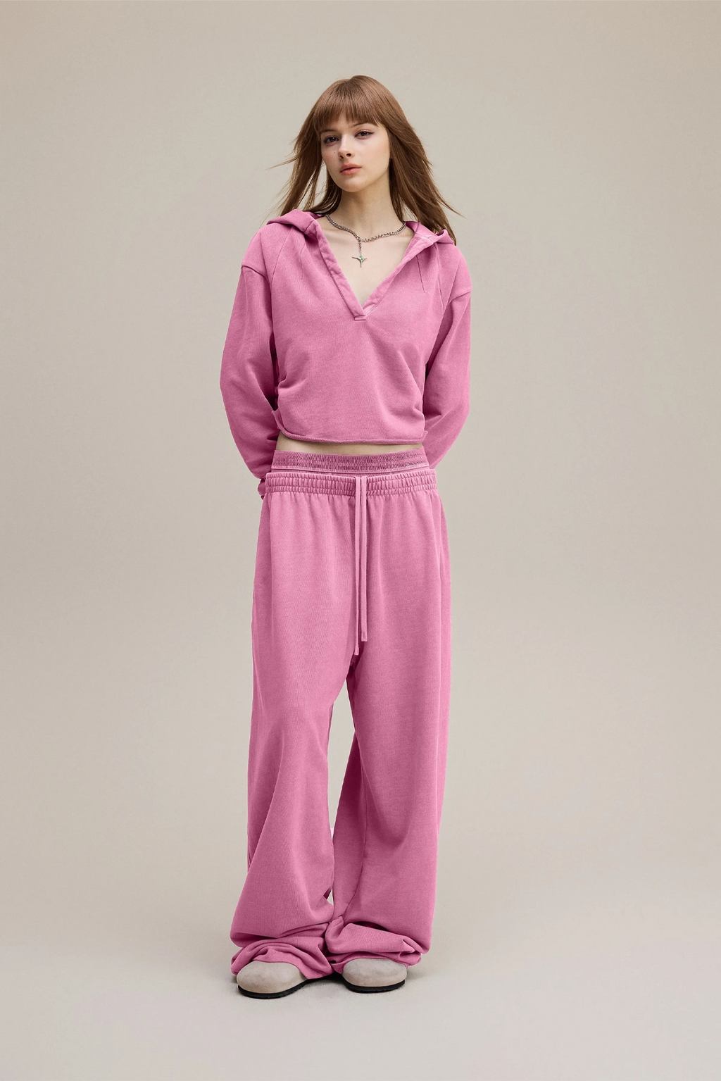 Person wearing a pink tracksuit on a plain background