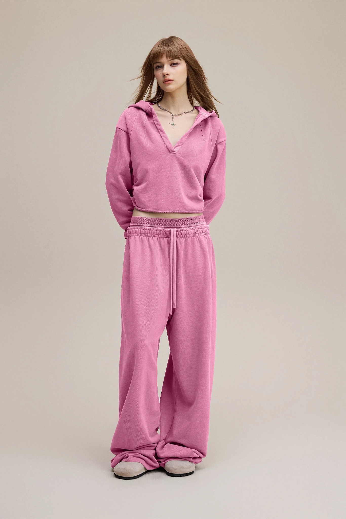 Person wearing a pink tracksuit on a plain background