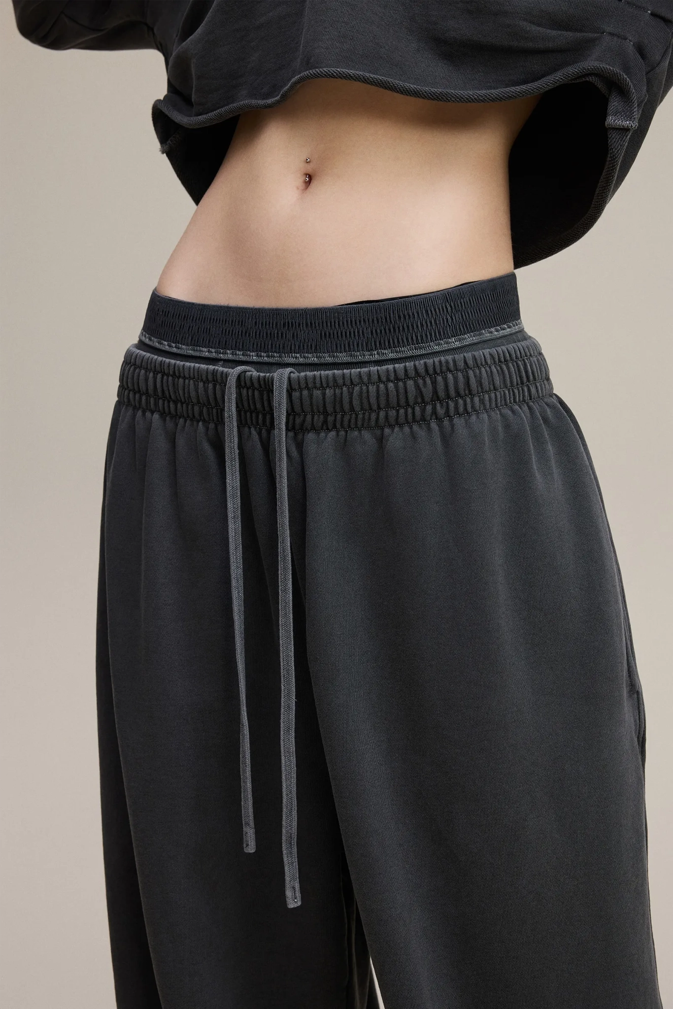 Black pants with drawstring waistband on a neutral background